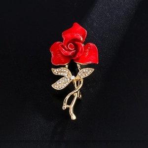 Elegant red rose brooch with gold stem and sparkling crystals on black background