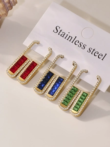 Detail of three pairs of gold-plated stainless steel padlock earrings with emerald-cut stones