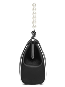 Detail of black Saffiano leather frame bag with white trim and pearl bead handle