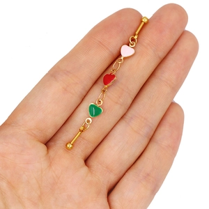 Close-up of golden industrial barbell with pink red and green heart charms on hand