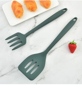 Deep green silicone spatula and fork spoon set on marble background with hanging holes