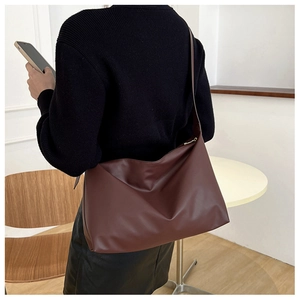 Model wearing dark brown large leather tote bag showing drape and size for commuting