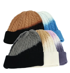 Dettaglio della trama a treccia pesante e motivi sfumati sui cappelli invernali