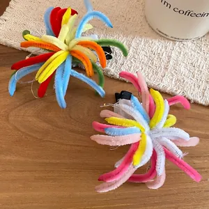 Colorful plush firework hair clips in vibrant and pastel tones on a wooden table