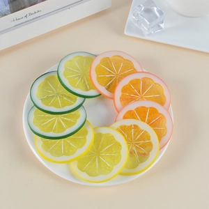 Lifelike PVC lemon and orange slices in green, yellow, and orange on a white plate