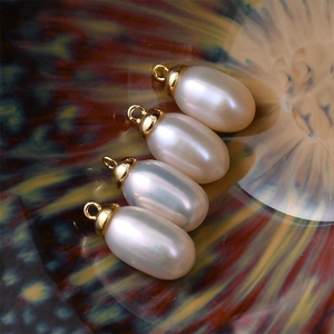 Detailed macro view of four oval white freshwater pearls with golden metal loop connectors