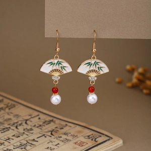 Macro detail of Chinese style fan-shaped earrings with green bamboo pattern and pearls