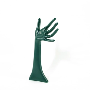 Macro detail of dark green resin hand-shaped jewelry stand for ring and bracelet display