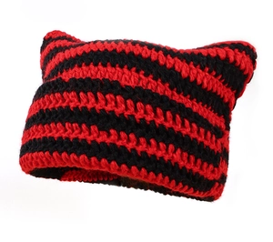 Close-up of red and black striped knit cat ear hat with gothic subculture texture