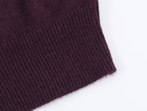 Vue macro de la maille côtelée violet foncé et de la texture douce du poignet du vêtement