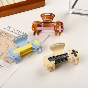 Three acetate cross hair claws in brown pink blue and white color block designs