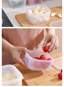 Close-up of transparent food container with drain holes for garlic and ginger storage