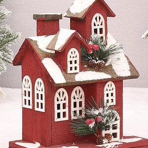 Detail of red wooden Christmas house with faux snow, pine needles and berries decor