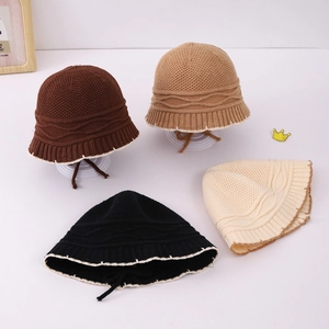 Detail of knit bucket hats showing wavy texture, chin straps, and contrast edges
