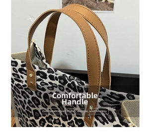 Close-up of leopard print tote bag with brown leather handles and gold rivet details