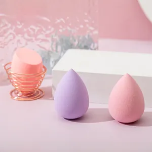 Detail of multi-shape makeup sponge set with rose gold storage stand on pink background