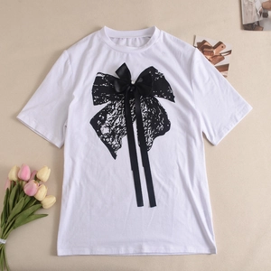 Détail d'un t-shirt blanc avec imprimé papillon en dentelle et nœud en ruban noir réel