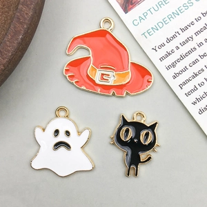 Macro shot of Halloween charms featuring a witch hat, white ghost, and black cat