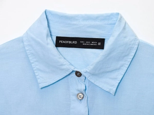 Detailed close-up of the light blue shirt collar showing quality stitching and brand label