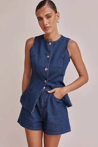 Texture dettagliata del gilet in denim blu scuro con tasche simmetriche e bottoni