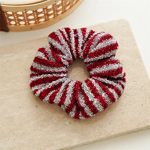 Detailed macro view of red and silver striped scrunchie with metallic glitter texture