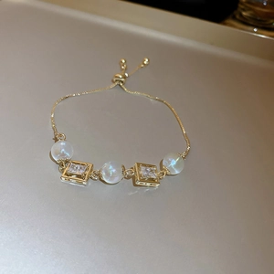 Adjustable gold chain bracelet featuring iridescent pearls and rectangular zircon details