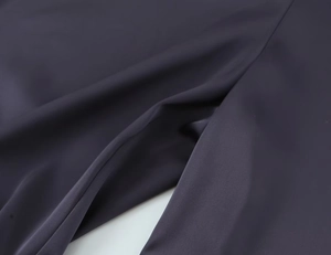 Vue macro détaillée montrant la texture lisse et l'éclat subtil du tissu satiné violet foncé