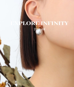 Gros plan de boucles d'oreilles pendantes en perles dorées portées par un mannequin chic