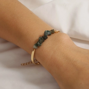 Close-up of a vintage chain bracelet with natural green crushed stones on a woman's wrist