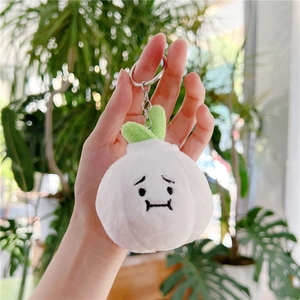 Close-up of cute plush vegetable pendant with sad embroidery and green leaves on top