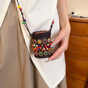 Detailed close-up of a handmade ethnic crossbody bag with colorful beads and sunflower wood chips