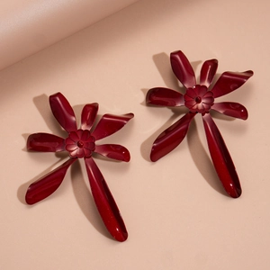 Detailed macro shot of red double-layered floral earrings with glossy painted metal finish