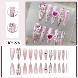 Pink cat-eye press-on nails set with rhinestones, pearl hearts, and almond shape design