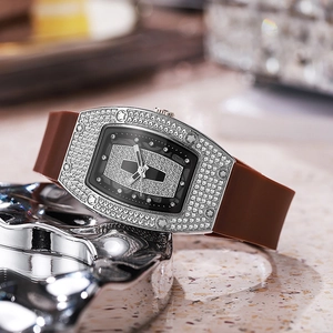 Tonneau-shaped women's luxury watch featuring full diamond casing and a brown rubber strap