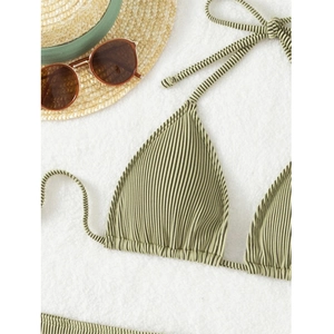 Close-up of olive green ribbed bikini top with halter neck ties on sandy texture