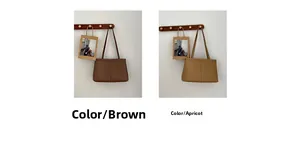 Detail view of large minimalist tote bags in brown and apricot on wooden hooks