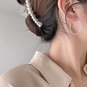 925 silver twist hoop earrings and pearl hair claw set worn by a model on a grey background