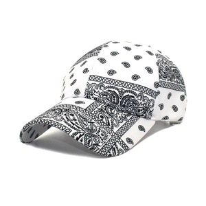 Detail view of stylish paisley bandana print on a white cotton baseball cap with curved brim