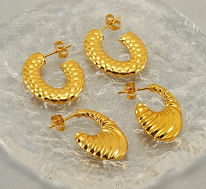 Detailed macro view of 18K gold-plated U-shaped earrings with hammered and spiral textures