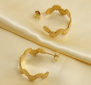 Détail de boucles d'oreilles créoles en acier plaqué or 18k avec bords en pétales de tournesol