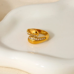 Detailed close-up of a gold-plated crossover ring with two rows of micro-paved zircons