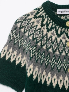 Detail of dark green Fair Isle knit cardigan featuring vintage gold embossed buttons