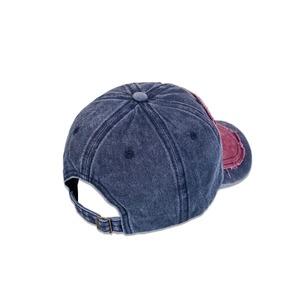 Detail of vintage washed baseball cap featuring a bronze metal buckle and distressed brim