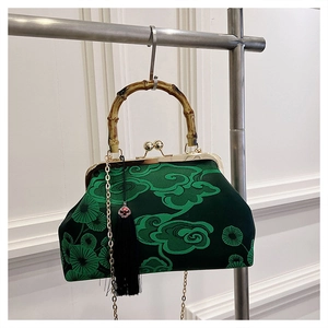 Detail der dunkelgrünen Seidenstickerei-Tasche mit Bambusgriff und eleganter Quaste