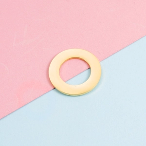 Close-up of a 25mm polished golden stainless steel hollow round pendant for DIY jewelry