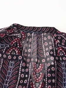 Close-up of neckline detail on paisley print chiffon blouse with geometric patterns