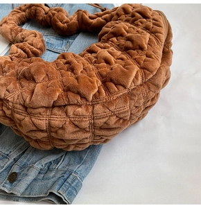 Close-up of caramel velvet quilted bag showing soft pleated texture and cloud-like handle