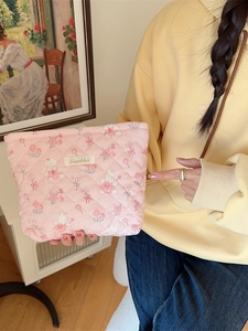 Pink quilted makeup bag with cute rabbit and cherry prints featuring a zipper closure