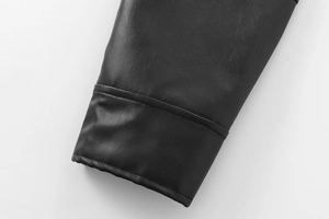 Detailed macro view of black faux leather aviator jacket texture and fine double stitching