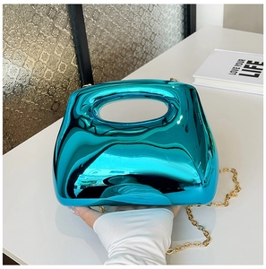 Detail of the high-gloss metallic turquoise acrylic clutch with a detachable gold chain